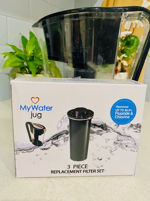 A MyWater jug filter set displayed with a background of greenery, showcasing its design and features emphasizing the removal of fluoride and chlorine.